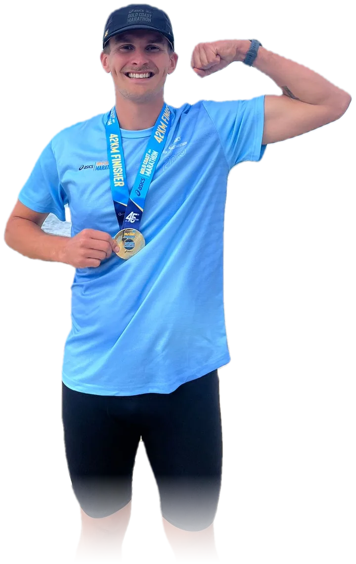 Toby holding his Gold Coast Marathon finisher medal and flexing